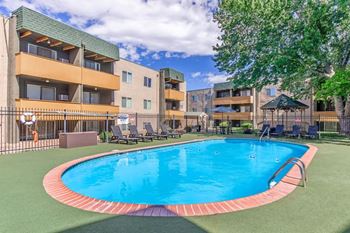 A swimming pool in a courtyard surrounded by apartment buildings.